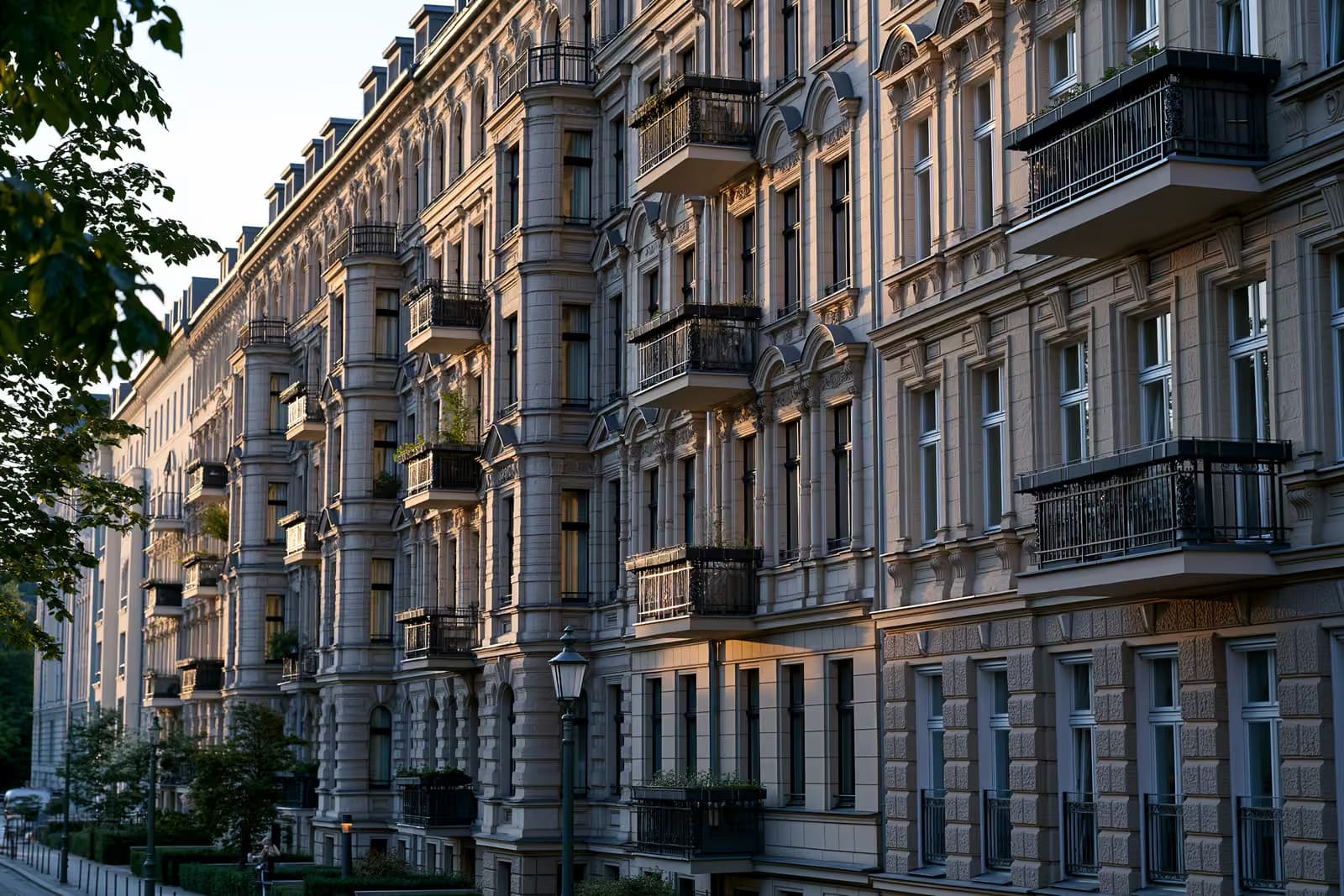 Rząd budynków mieszkalnych w niemieckim mieście z tabliczką „do wynajęcia” w oknie