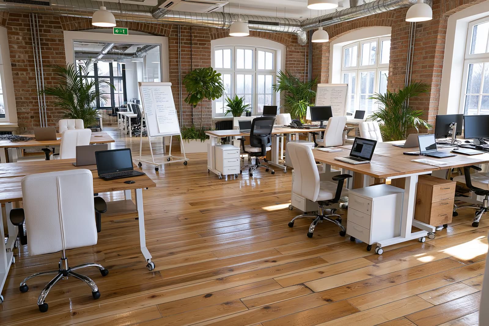 Założyciele pracują razem przy biurkach w nowoczesnym niemieckim biurze startupowym.